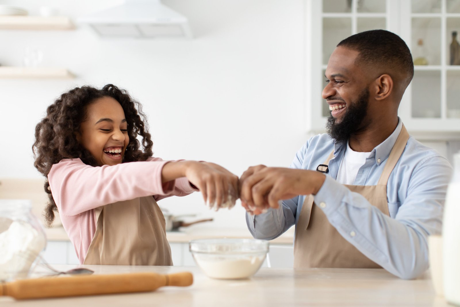 Happy black man and his daughter preparing dough Sugarspoon Desserts